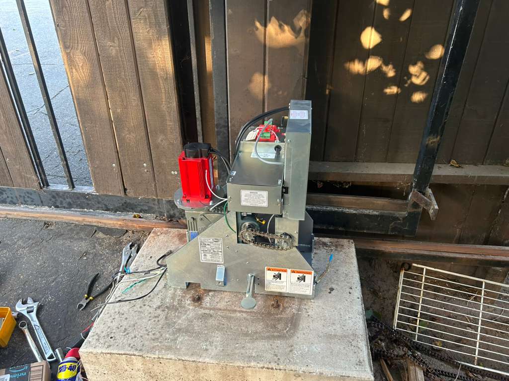 Gate motor and opener unit installed beside wooden gate in Los Angeles, CA